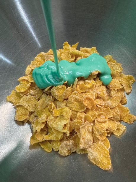 Pouring green chocolate onto cornflakes